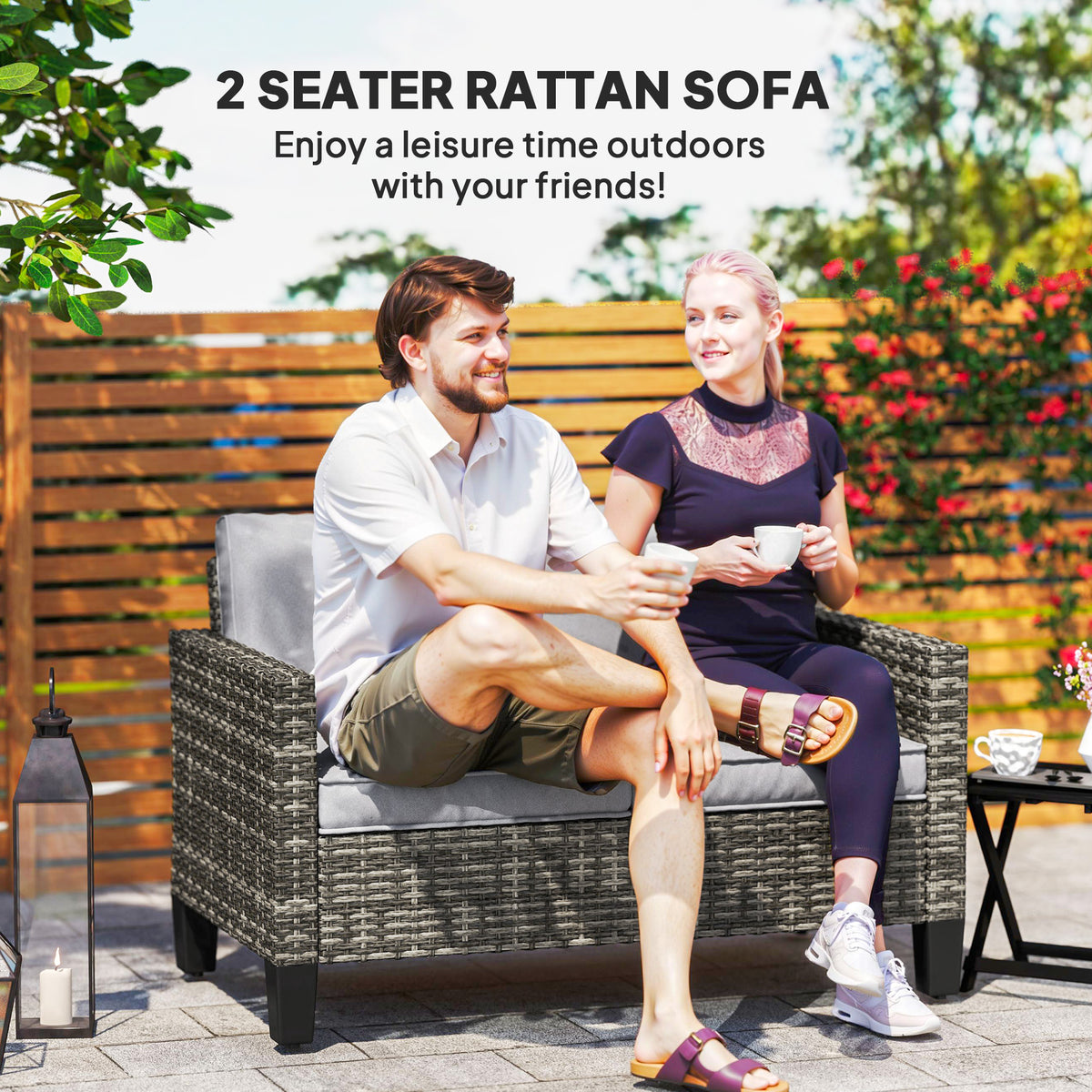 Outsunny two-seat rattan sofa with gray cushions, shown with two seated people