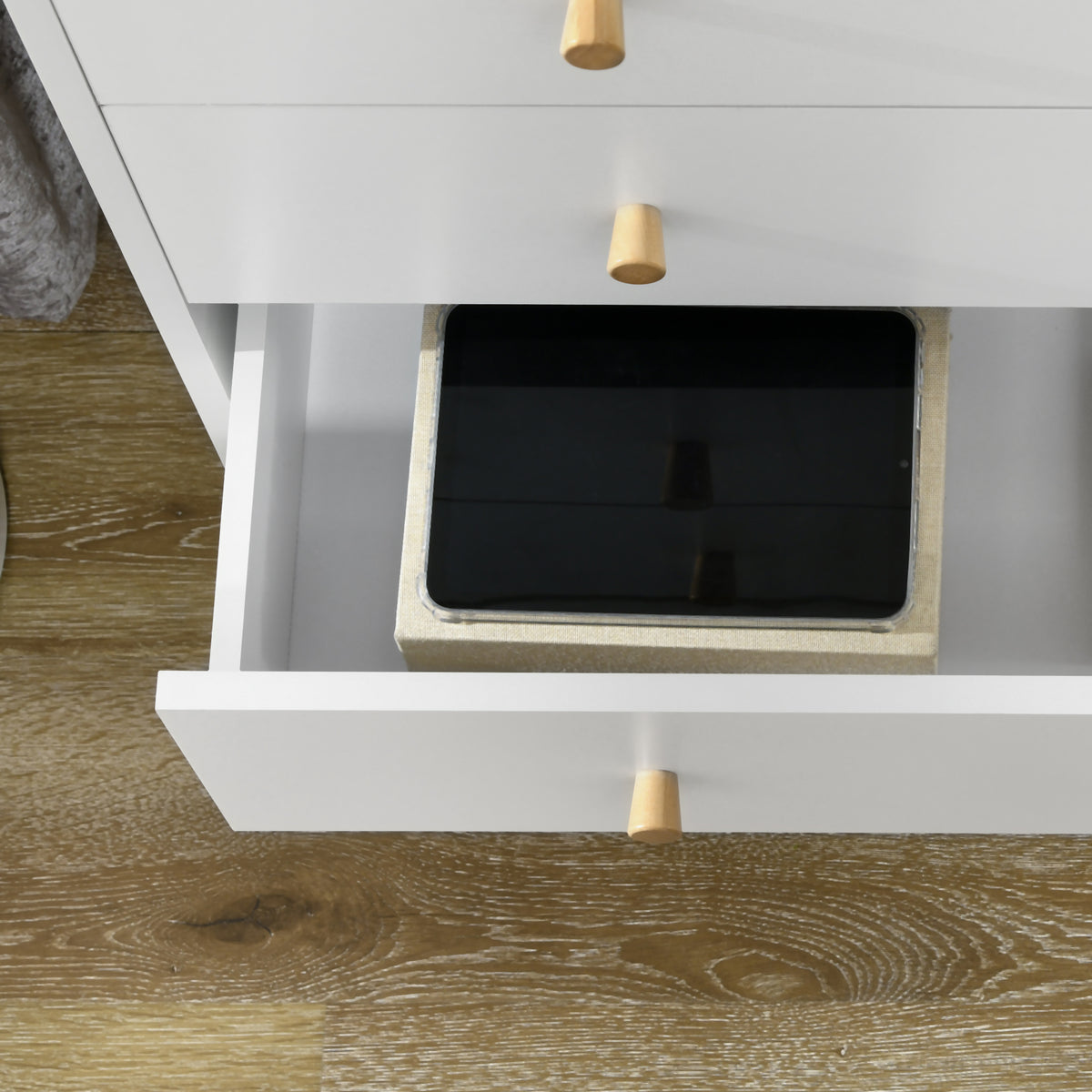 Open drawer of the white chest showing its interior storage space