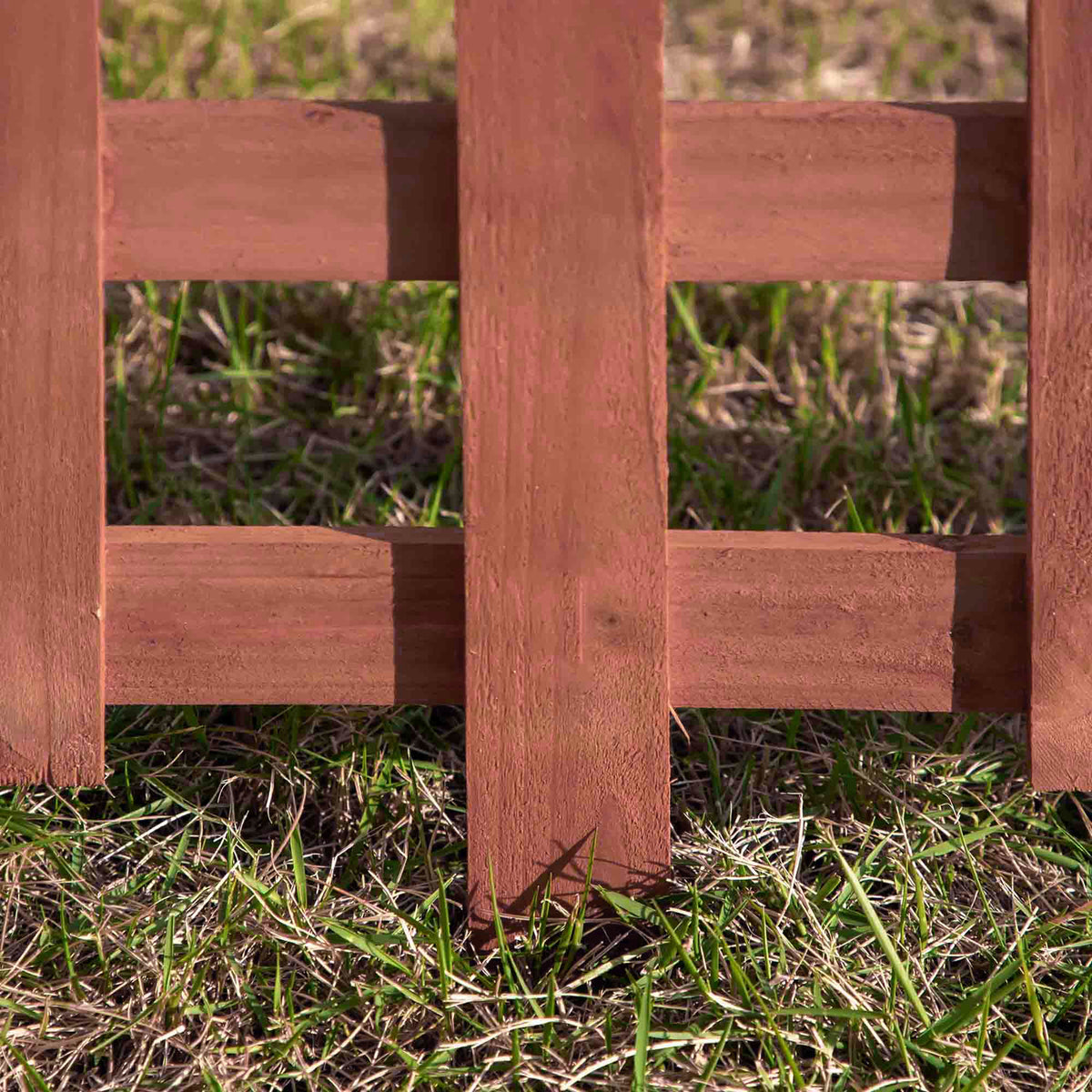 Close-up of wooden garden fence pickets joined by two horizontal rails.