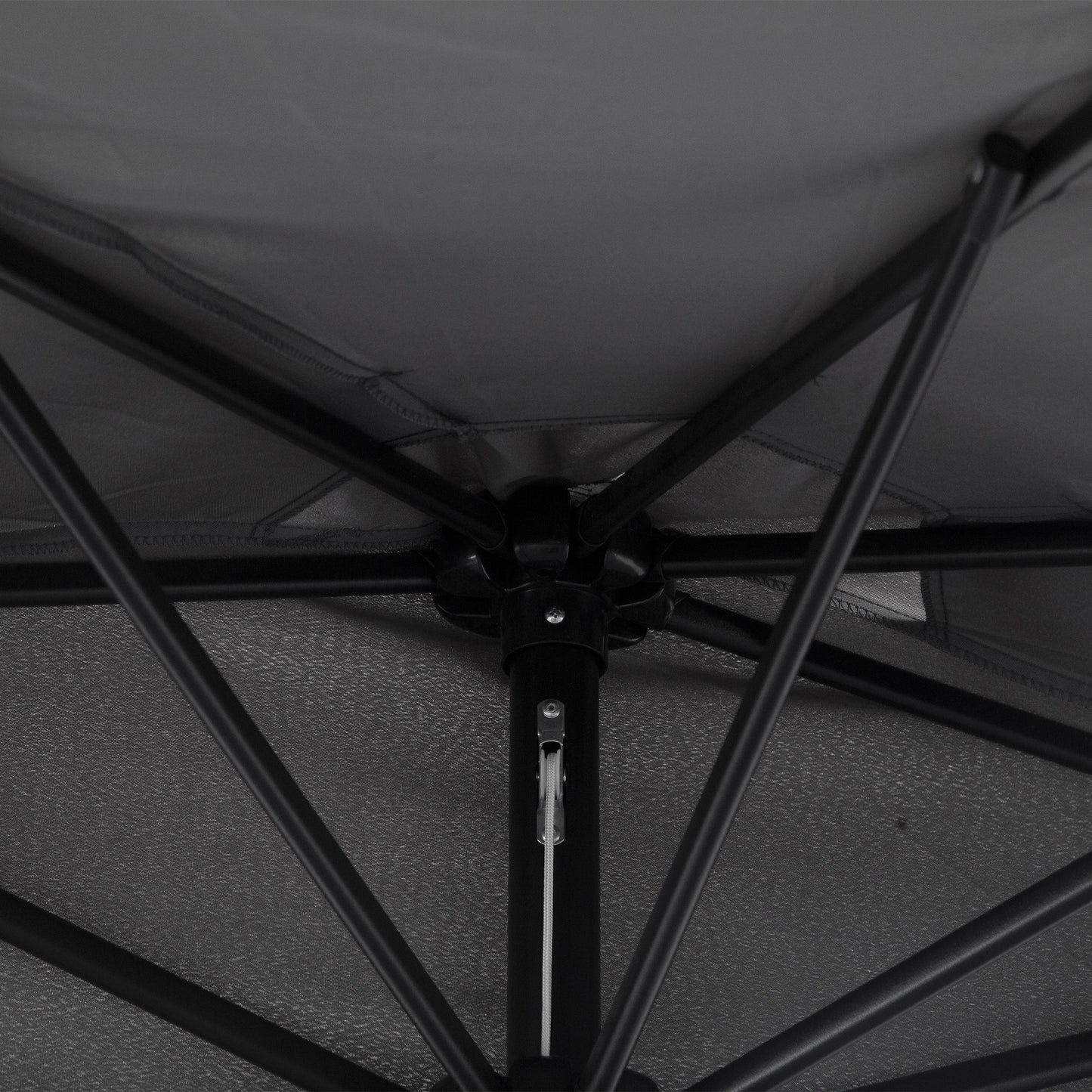 Close-up of the umbrella's black metal frame, ribs and center joint