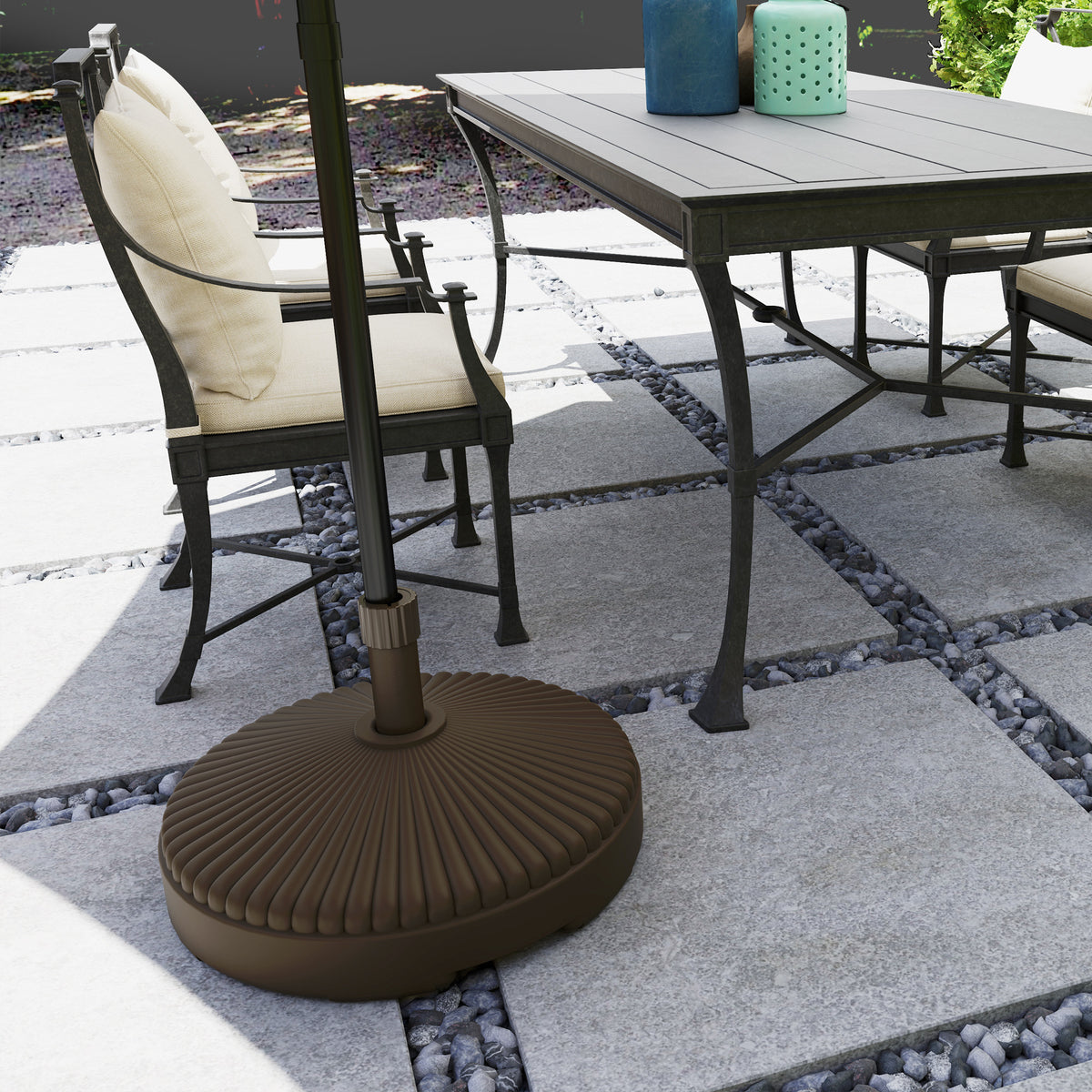 Outsunny brown umbrella base holding a patio umbrella beside outdoor dining furniture