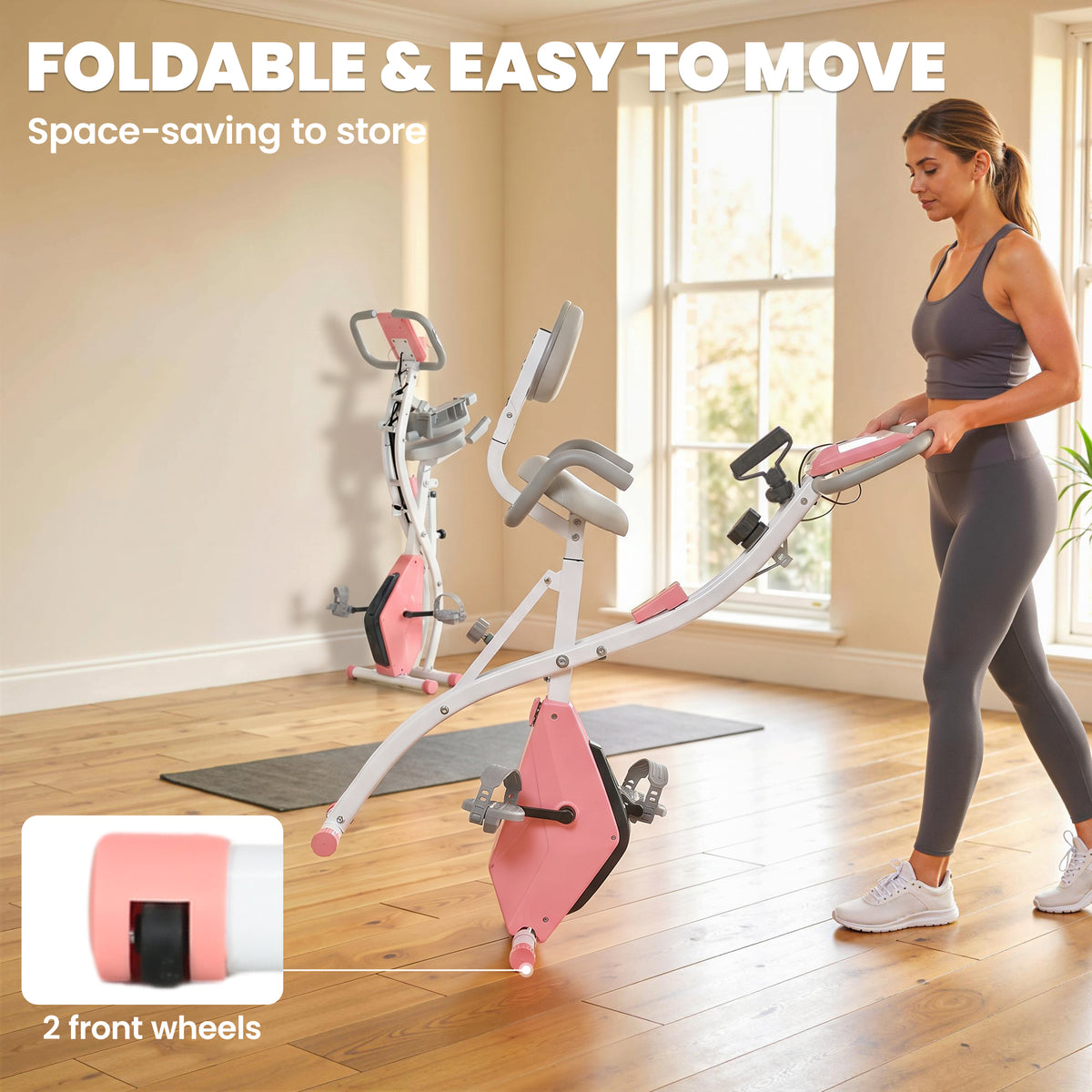 Pink and white folding exercise bike partly collapsed for storage, with front transport wheels.