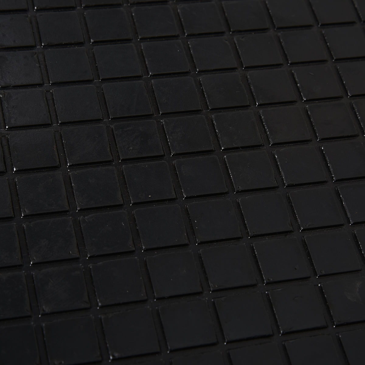 Close-up of the motorbike lift's black rubber platform with raised square grip pads.