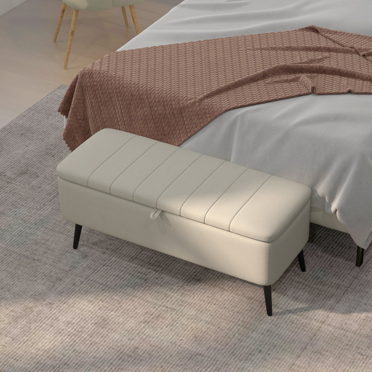 Cream white storage ottoman positioned at the foot of a bed