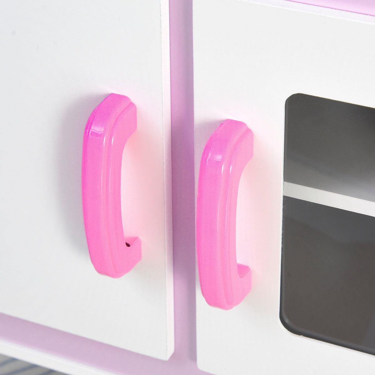 Pink handles on the doors of a kids' pretend kitchen playset