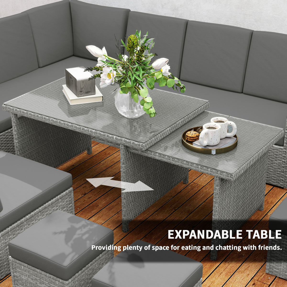 Expanding rattan table shown extended beside the cushioned garden sofa