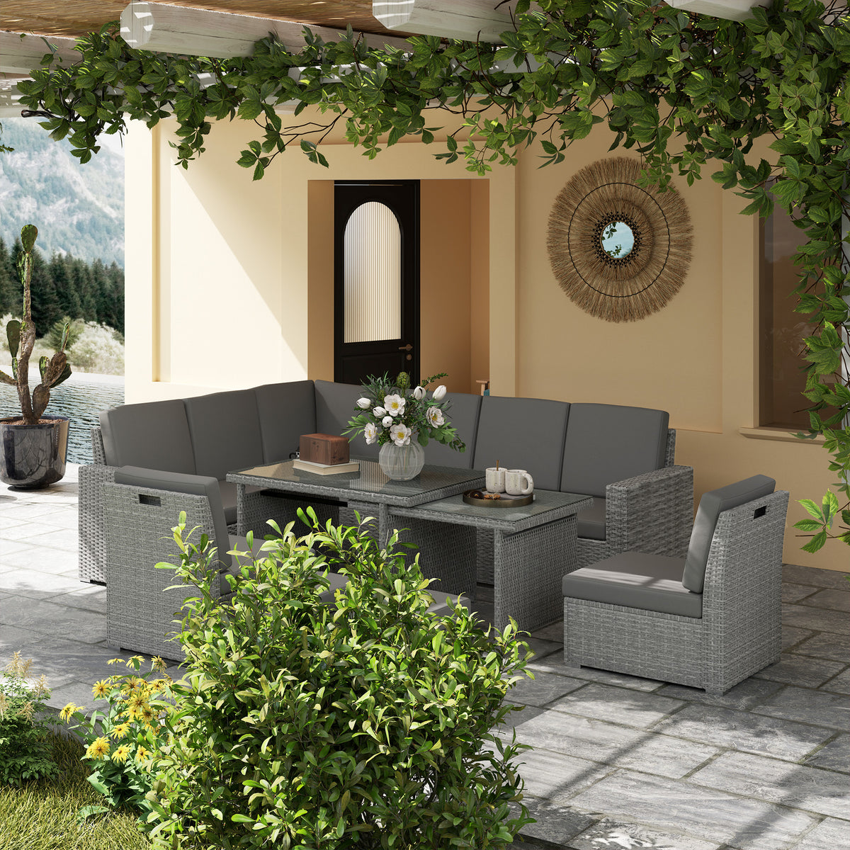 Light grey rattan garden sofa set arranged with an expanding table and armchair