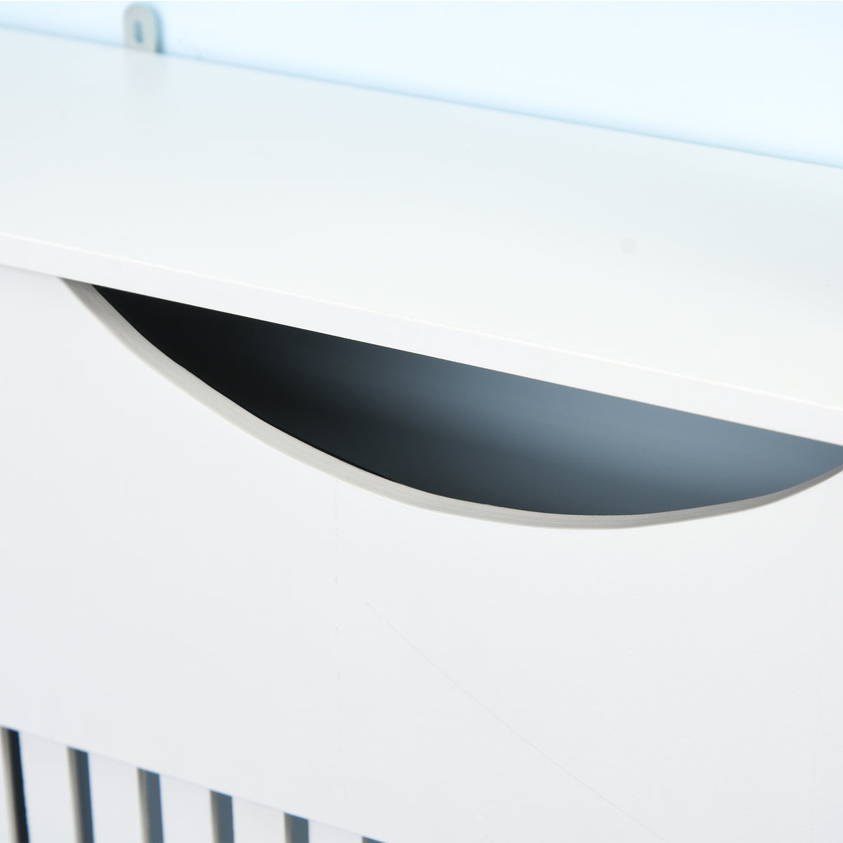 Close-up of the white radiator cover cabinet's curved hand opening beneath the top shelf