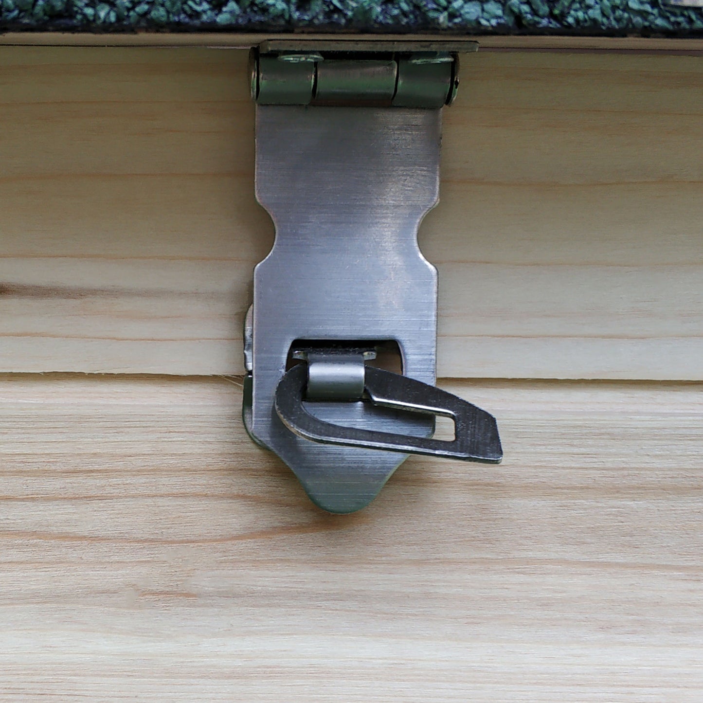 Close-up of metal latch on the wooden chicken coop