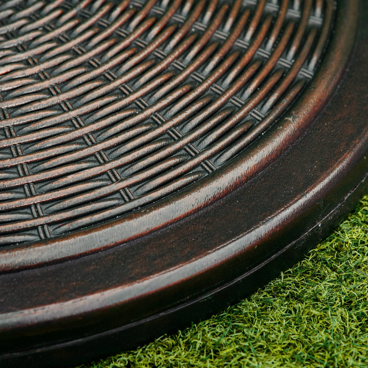 Close-up of the parasol base's antique-look woven surface and rounded edge