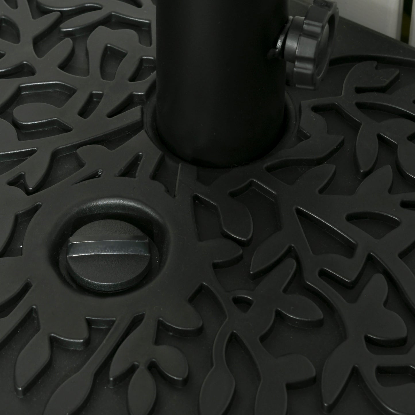 Close-up of the base's patterned top, fill cap, and pole holder knob
