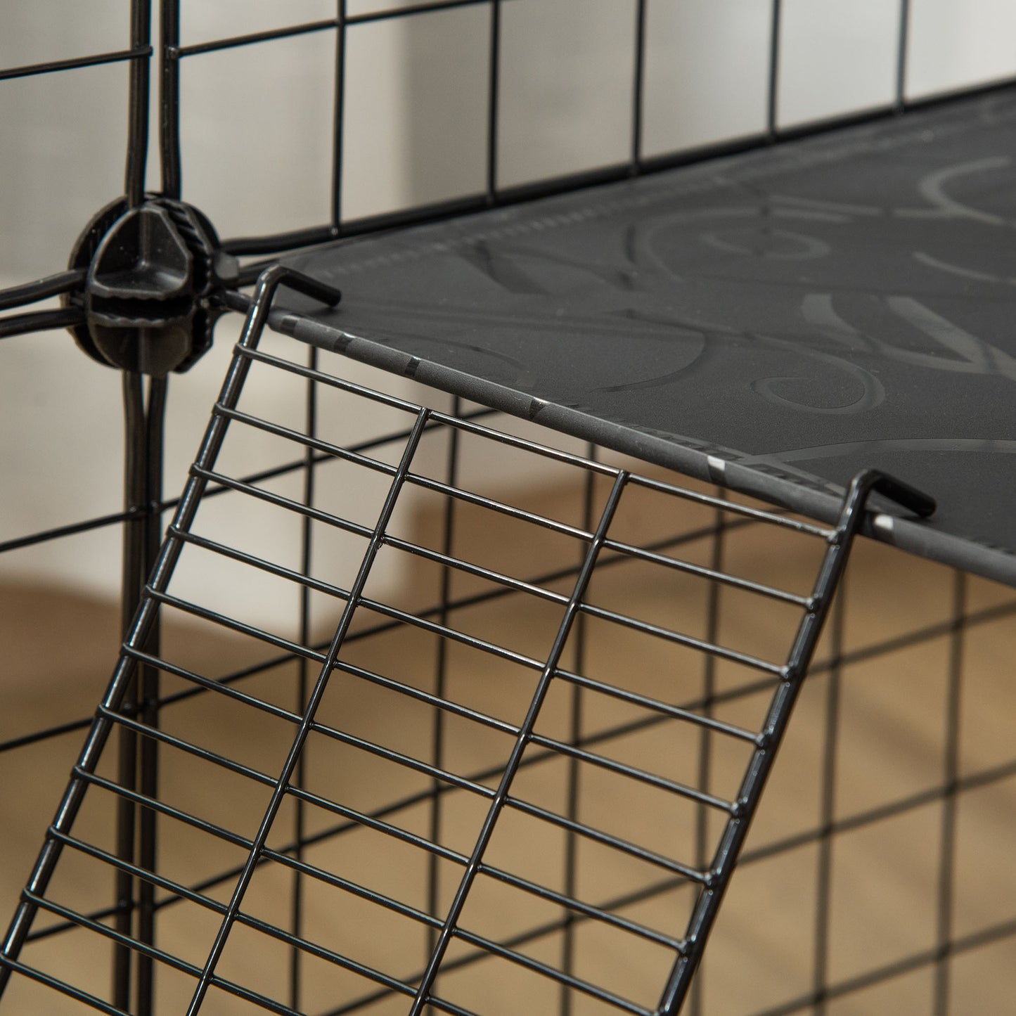 Close-up of the black wire playpen ramp connecting to a resin platform.
