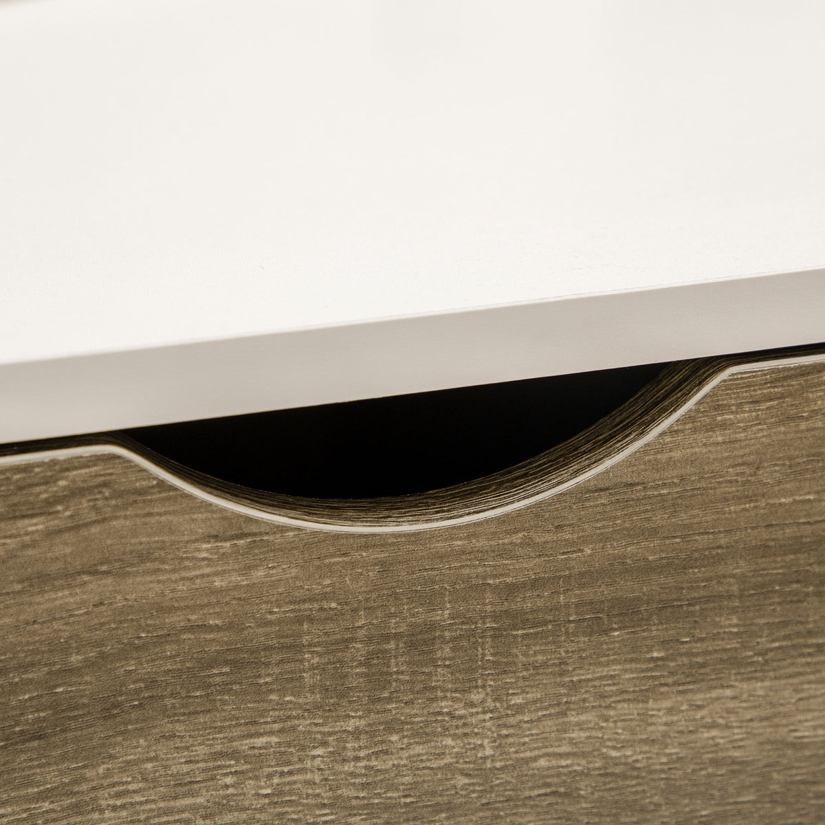 Coffee table drawer close-up showing the recessed curved pull and wood-grain front