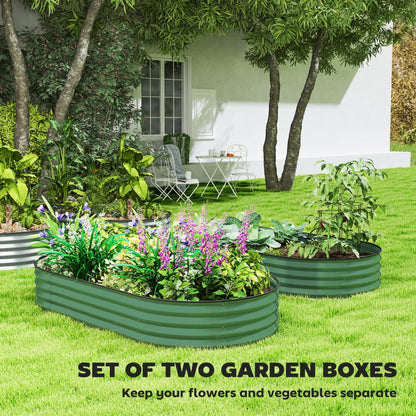 Two green oval steel garden planters filled with flowers and vegetables