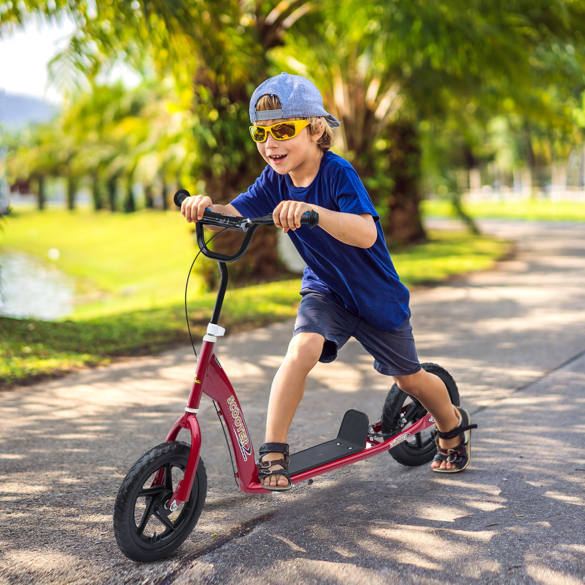 Red HOMCOM kids kick scooter with large black tires, ridden by a child