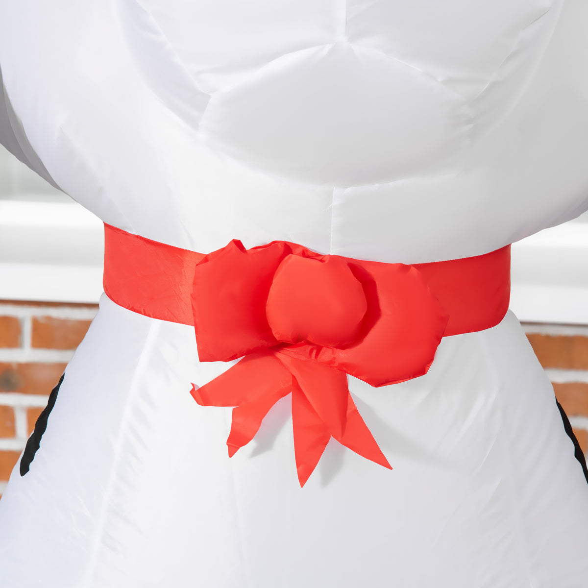 Close-up of the inflatable puppy's red neck bow and white fabric.