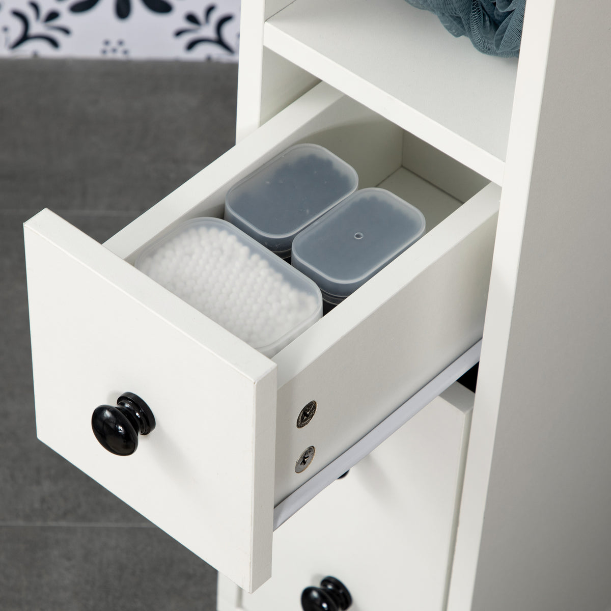 Close-up of the white cabinet's open drawer with toiletries inside