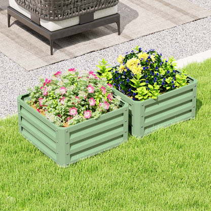 Two light green steel planter boxes filled with pink and yellow flowers