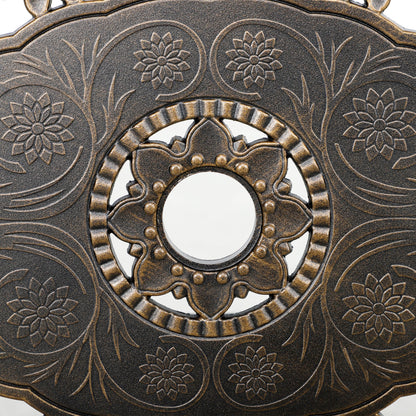 Close-up of floral bronze-tone table pattern surrounding the parasol hole