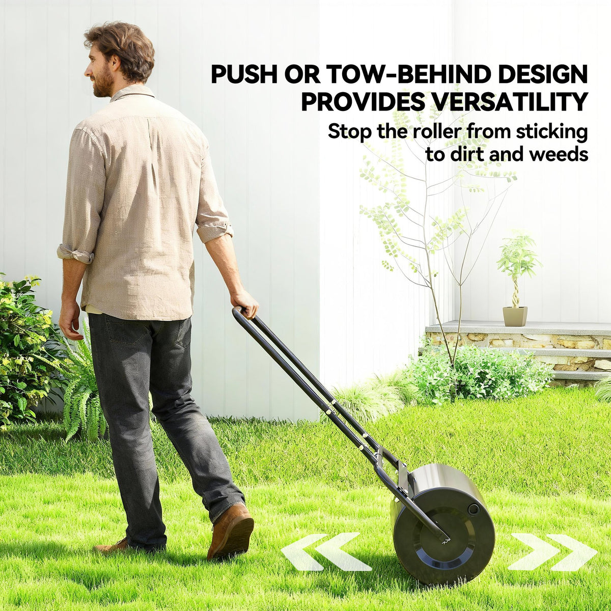 Black lawn roller being pulled across grass with its long handle
