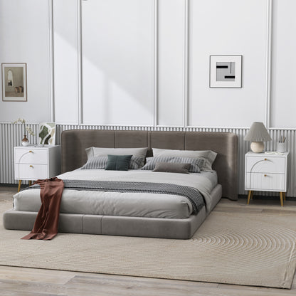 White two-drawer bedside table with arched fronts and gold accents beside a bed