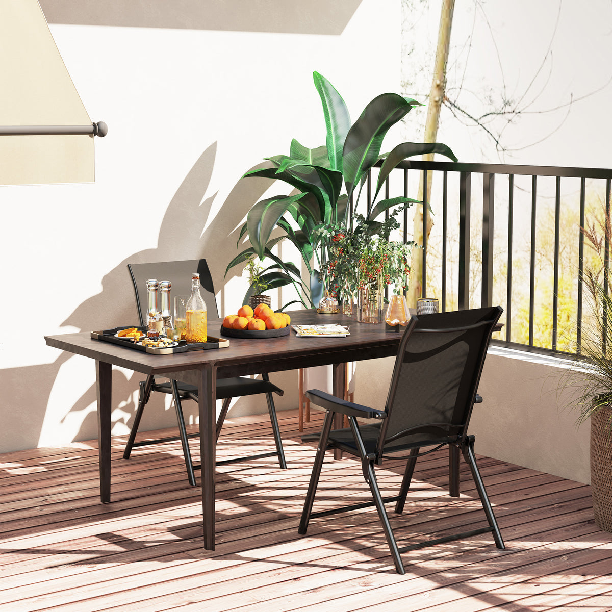 Black mesh folding chair beside an outdoor dining table, viewed from the back