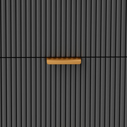 Close-up of the bedside table's black fluted drawer front and gold-tone handle