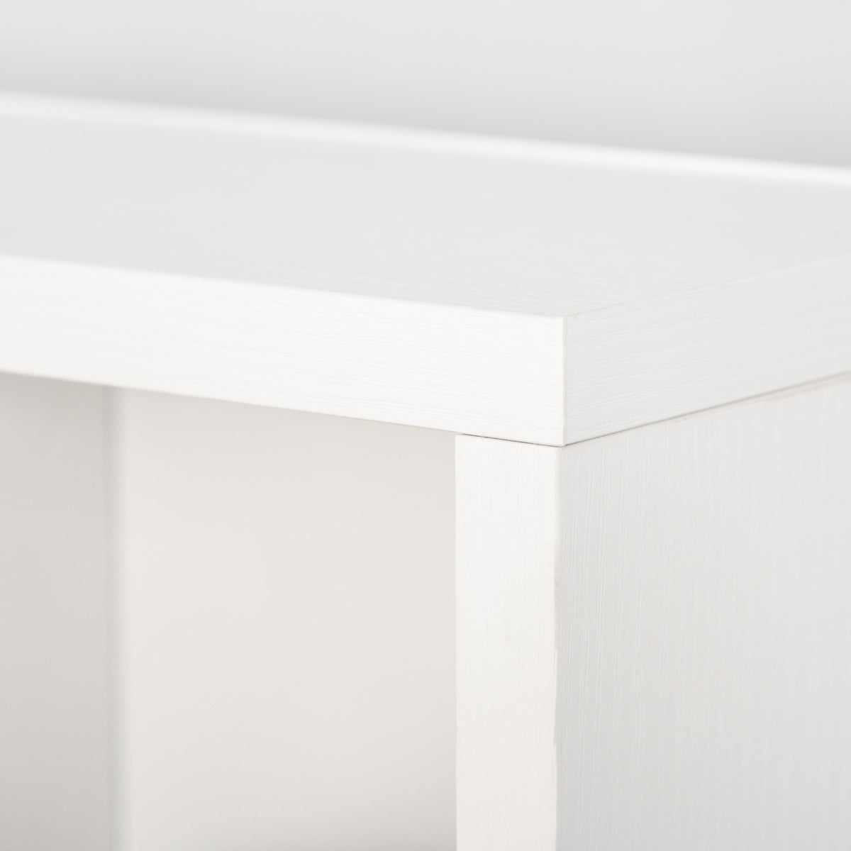 Close-up of the white storage unit's top and side panel joint