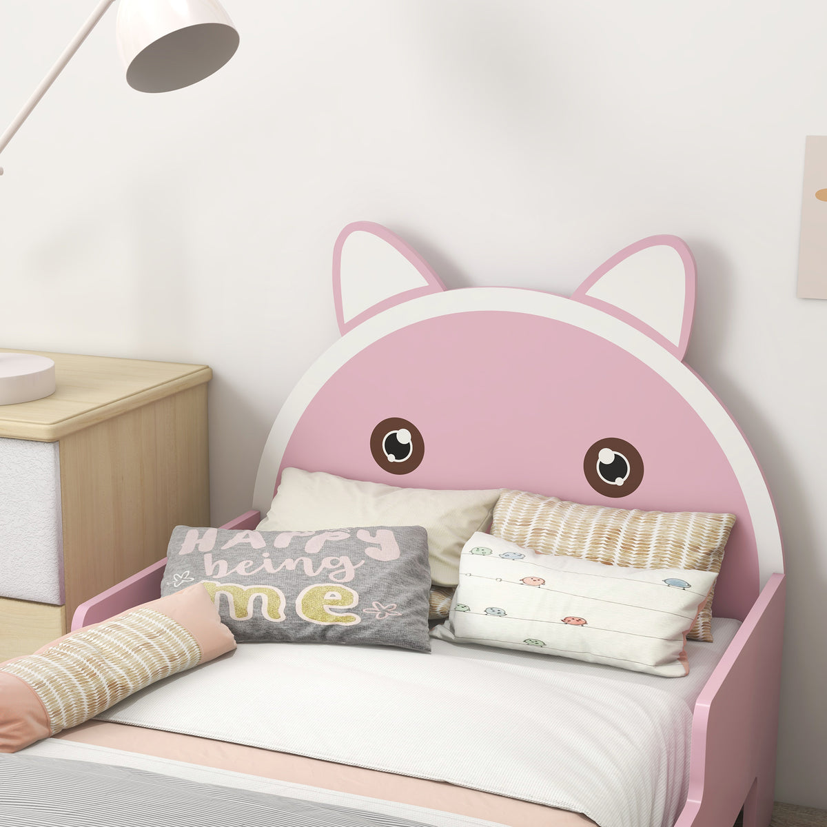 Pink toddler bed with cat-shaped headboard and side guardrails, shown made up with bedding