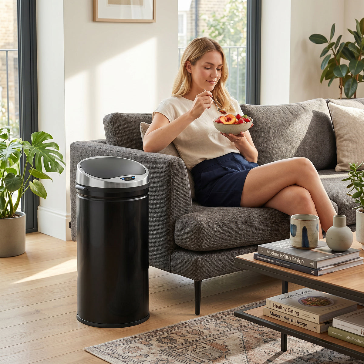 HOMCOM black round sensor bin beside a living room sofa
