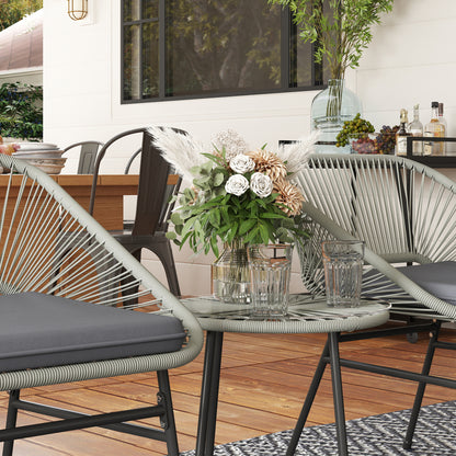 Glass-top round table between two light gray wicker chairs with gray cushions