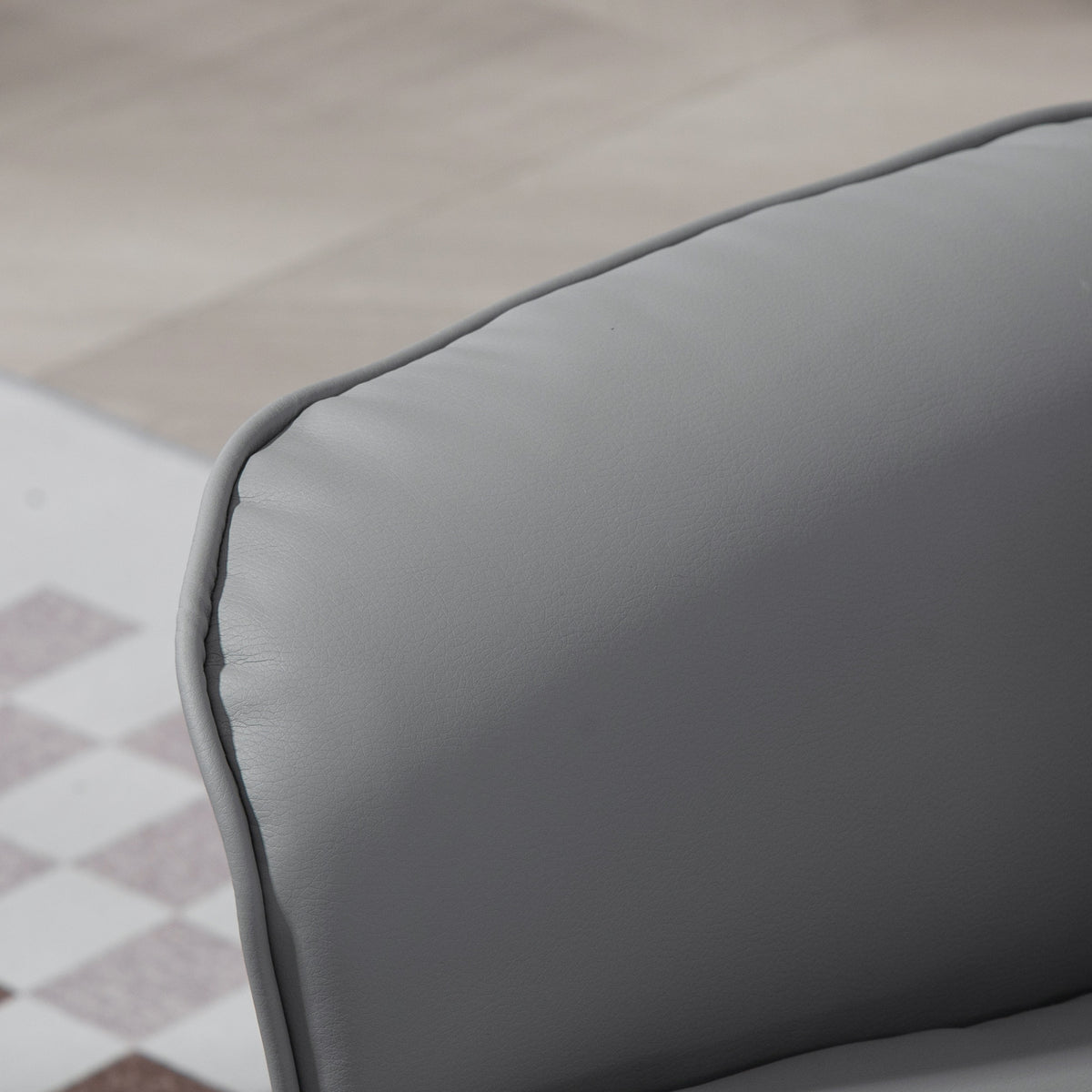 Close-up of the recliner's light gray PU leather upholstery and stitched edge