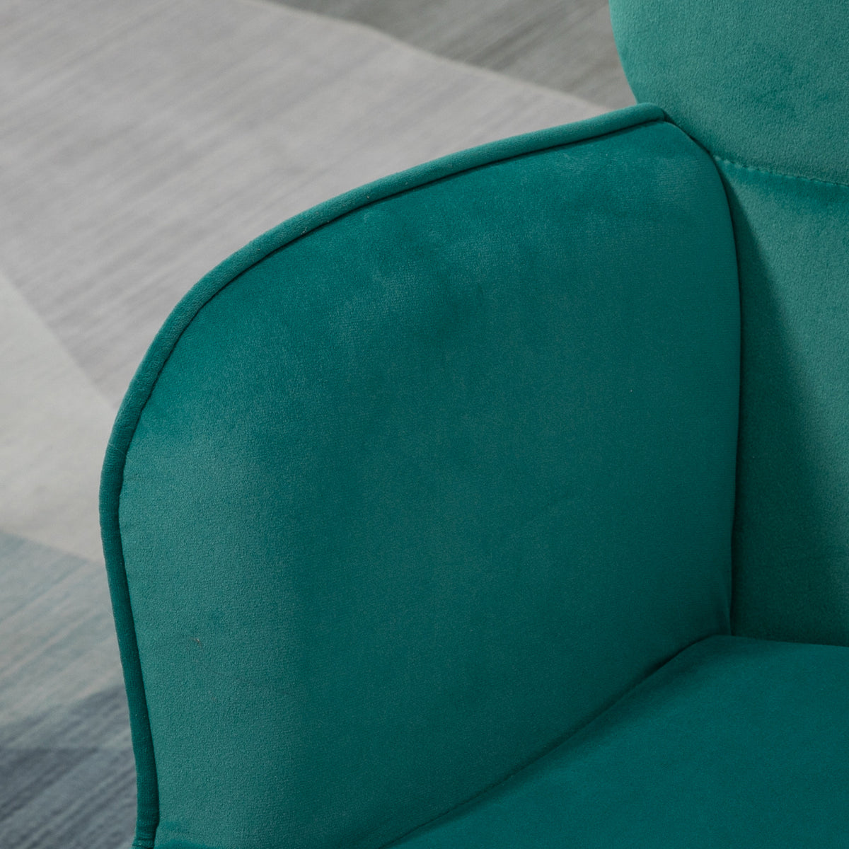 Dark green velvet armchair with a rounded, padded armrest
