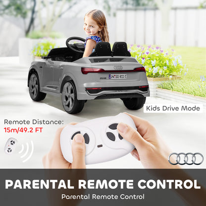 Grey Audi ride-on car shown from the rear with a child driver and handheld parental remote