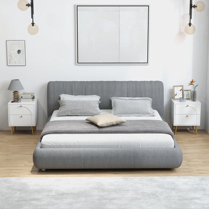 Pair of white bedside tables with two drawers, gold knobs, and tapered legs beside a bed