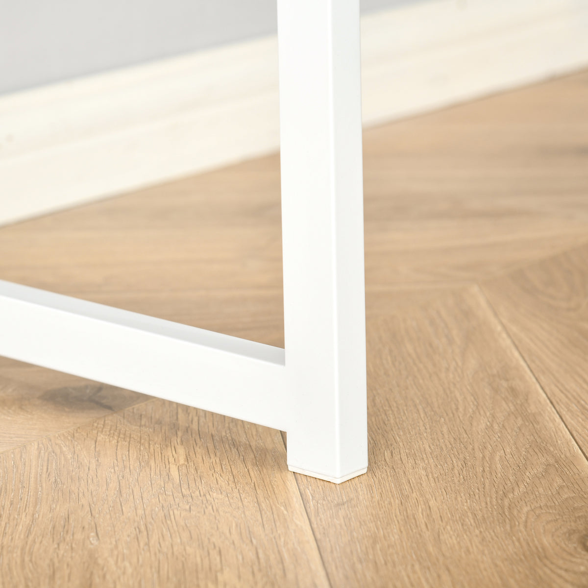 Close-up of white metal desk leg and floor-protecting foot