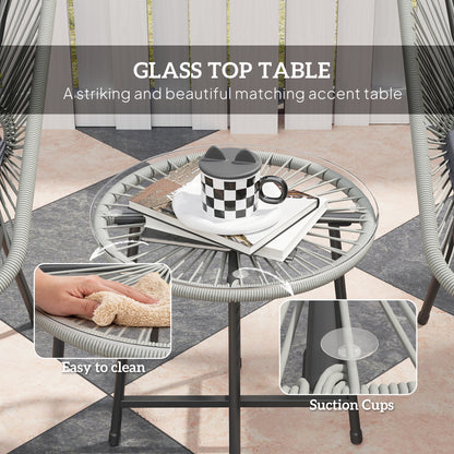 Round glass-top wicker bistro table with suction cups securing the glass