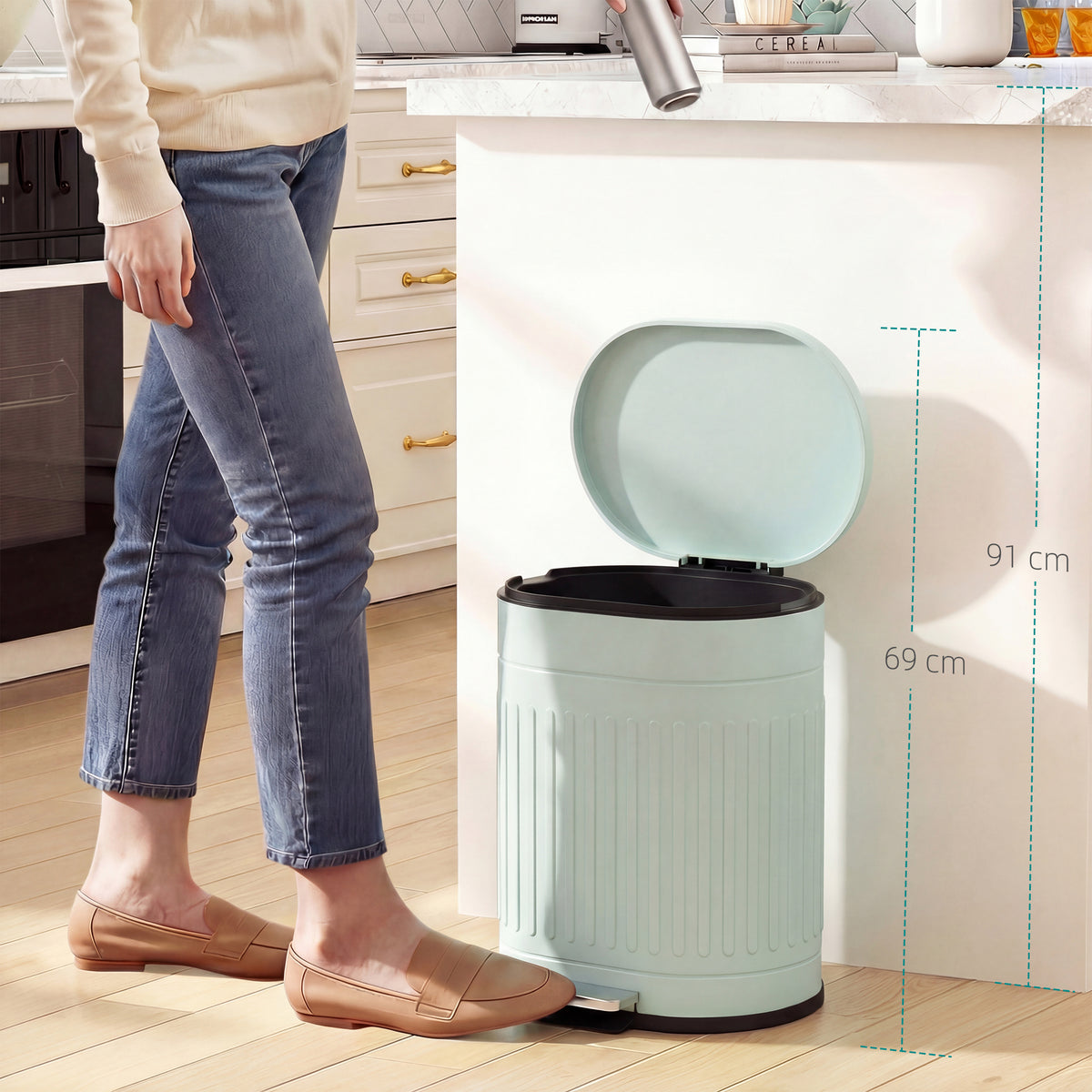 Light green kitchen bin with open lid and foot pedal beside a person