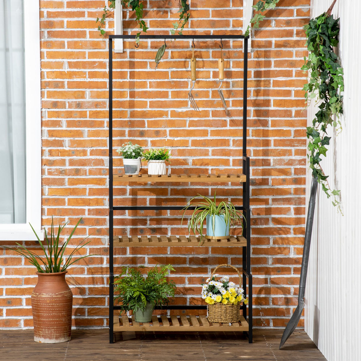 Three-tier plant stand with wood shelves and hanging hooks, holding potted flowers