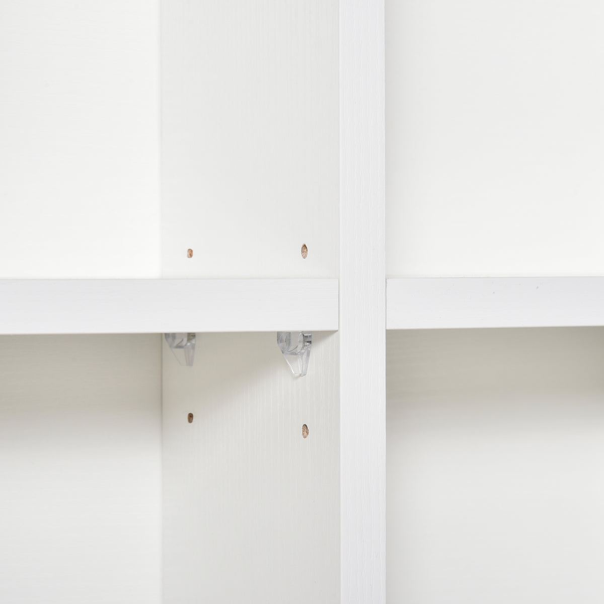 Close-up of shelf support clips inside the white storage unit