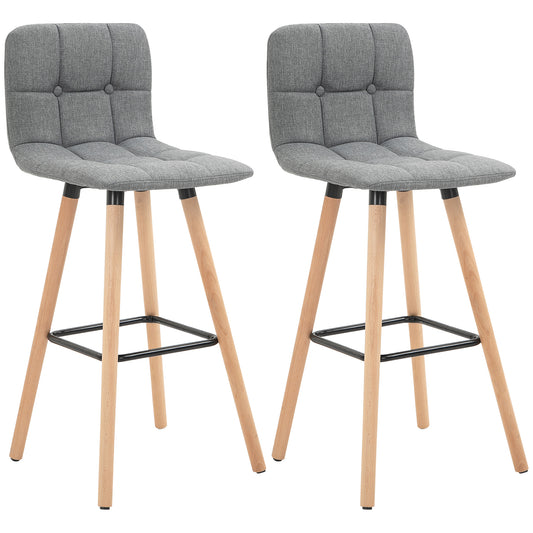 Two gray button-tufted counter stools with padded seats, wood legs, and black footrests