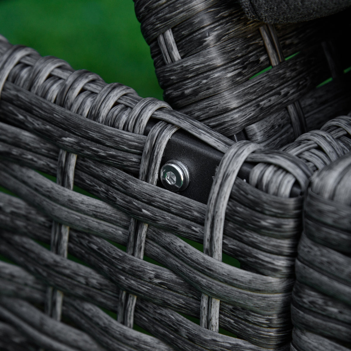 Close-up of wicker lounger frame joint with metal bolt fastening the woven sections