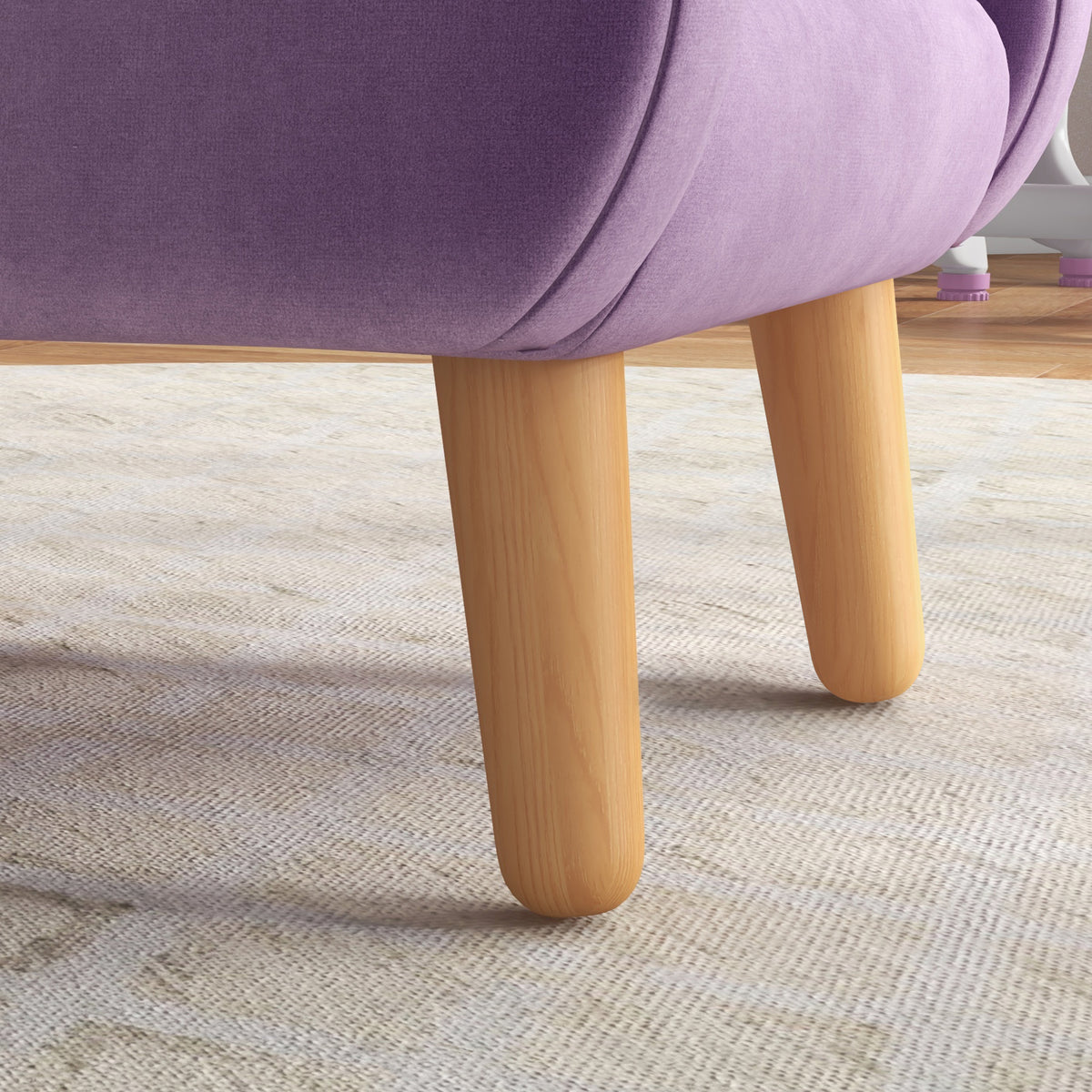 Close-up of light wood legs beneath the purple velvet armchair