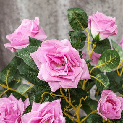 Close-up of pink artificial rose blooms and textured green leaves