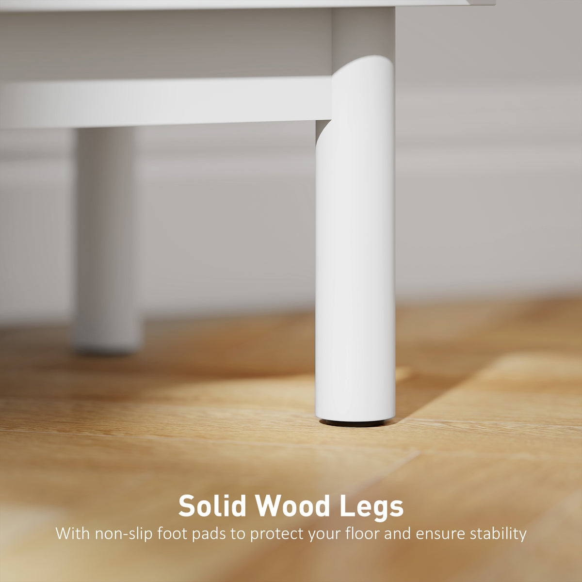 Close-up of a white solid wood bedside table leg with a non-slip foot pad
