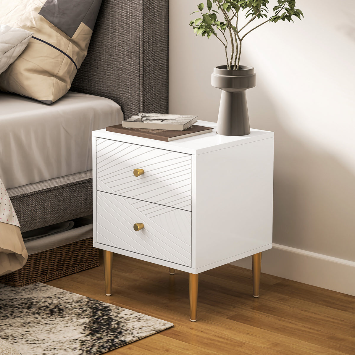White two-drawer bedside table with diagonal carved fronts and gold-tone legs