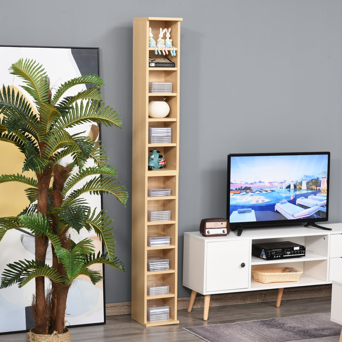 HOMCOM slim natural wood media tower beside a TV, displaying discs and decor