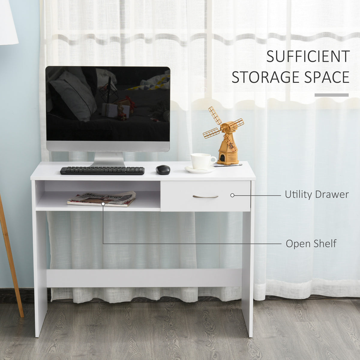 White writing desk with an open shelf and drawer, shown with a computer and accessories.