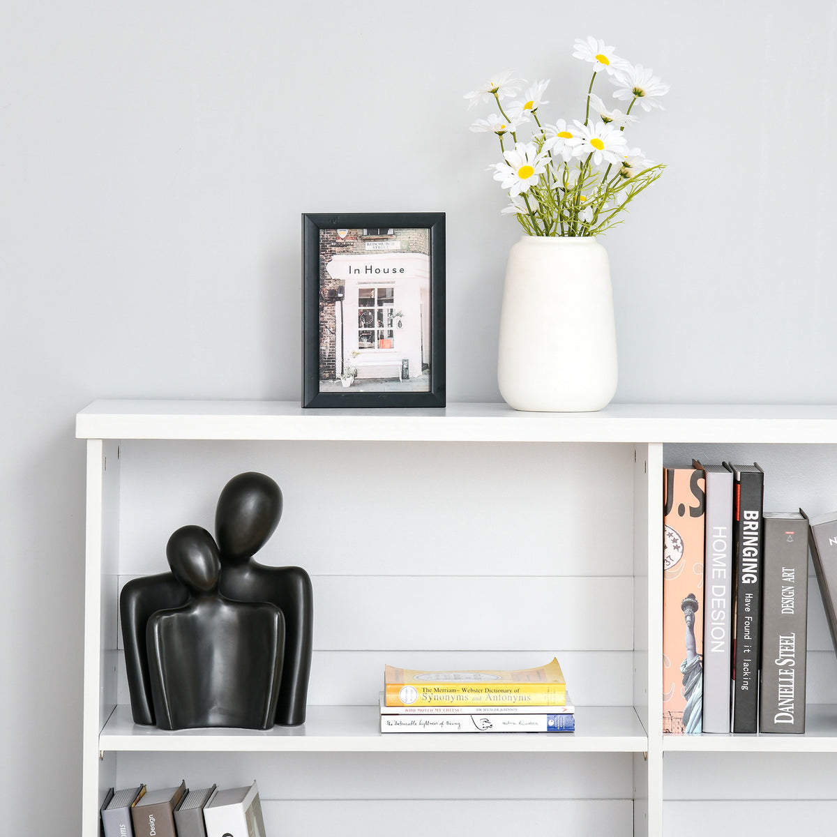 White bookcase detail showing an open shelf with books and decor