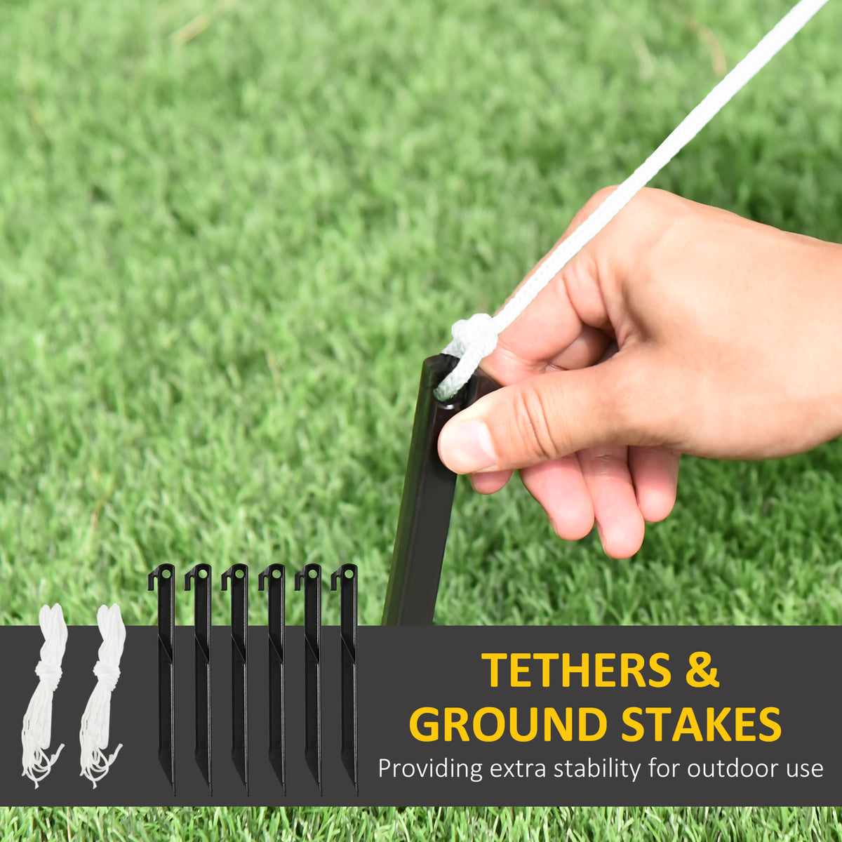 Outdoor anchoring kit with black ground stakes and white tethers for an inflatable decoration.